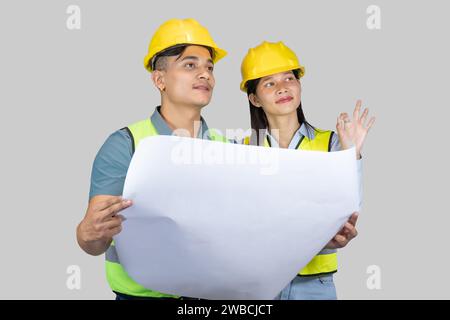 Asian Couple Engineer and Architect giving gestures and expressions on construction field Stock Photo