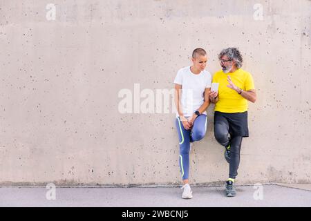senior man and young woman talking and using phone Stock Photo