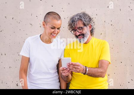 senior man and young woman smiling using a phone Stock Photo