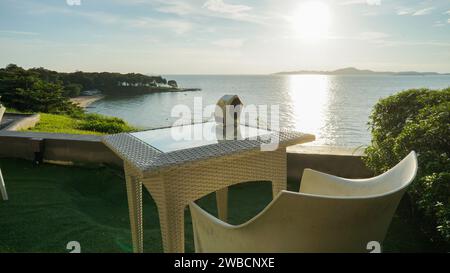 Romantic table for diner next to the sea with beautiful sunset sky. Table of a restaurant to the shore of the sea. Stock Photo