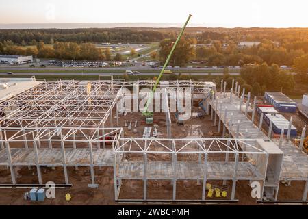 Drone photography of constructions site of large commercial building with construction machinery and construction workers during autumn sunny morning Stock Photo