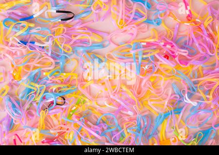 Colorful elastic rubber bands isolated on pink background. Colorful children's hair bands, flexible, made of para rubber. Stock Photo