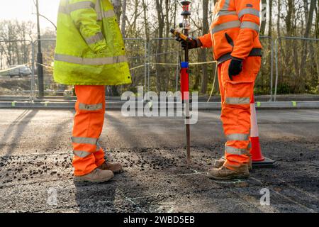 Site engineer surveyor and site manager discussing plan of works on construction site during new road construction Stock Photo