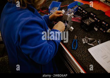 Close-up of hands of young computer engineer fixing broken pc parts at the desk in the home office. Stock Photo