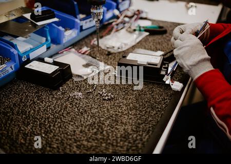 Man drilling wood with battery power Drill on the table at home. Stock Photo