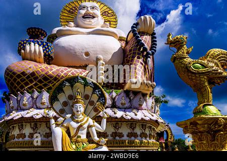 Budai Buddha statue, and temple skyline, Wat  Plai Laem, Bo Phut, Ko Samui, Thailand Stock Photo