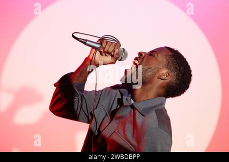 Young Black Man Singing into Microphone Stock Photo