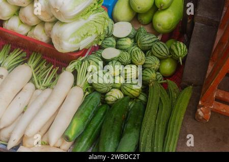 Fresh vegetables on a stall in Mae Klong Railway Market, a local market in Bangkok, Thailand. Green fresh vegetable stall Stock Photo