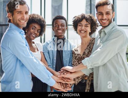 a group of successful business diverse people in the office stands embracing Stock Photo