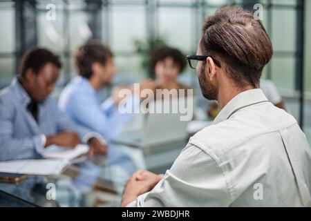 business man with executives working in background in office Stock Photo