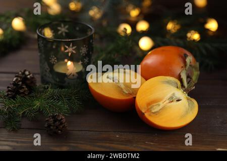 Bright orange persimmons sliced on the wooden background Stock Photo
