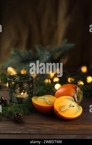 Bright orange persimmons sliced on the wooden background Stock Photo