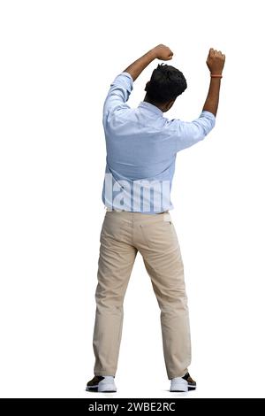 A man in a blue shirt, on a white background, standing tall, waving his arms, back view Stock Photo