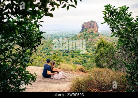 Couple in Sigiriya on honeymoon or family vacation. Woman and man on mountain in summer. Happy people and beautiful green landscape view. Stock Photo