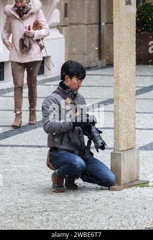 Photo of a photographer on the streets of the city Prague in Czech republic looking at his camera Stock Photo