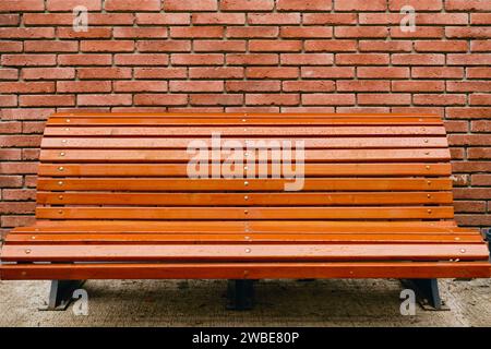 Bench on red brown vintage brick wall texture background, concept horizontal wide brick wall background or abstract web banner Stock Photo