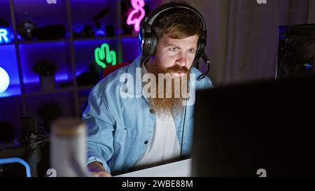 Handsome irish redhead streamer locked in serious game on his decked-out gaming rig, night streaming session from his decked-out gaming room Stock Photo