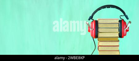Relaxing with audiobooks concept with heap of books and vintage headphones.Bright green background with large copy space Stock Photo