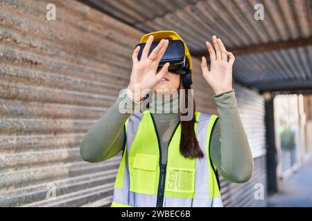 Young beautiful hispanic woman architect using virtual reality glasses at street Stock Photo