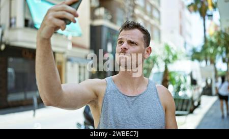 Handsome bearded man takes selfie on sunny urban street Stock Photo