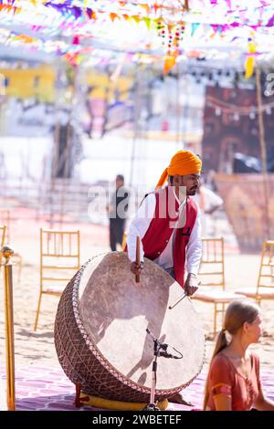 Unidentified tourists playing drums in colorful clothes at fair ground during the pushkar camel fair. Stock Photo