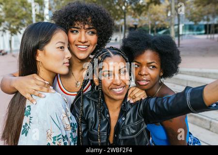 Cute multi-ethnic women and transgender person taking a selfie together Stock Photo