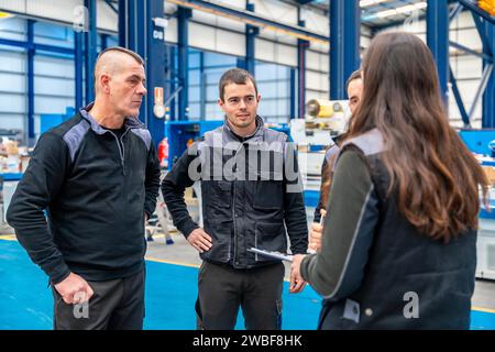 Team of workers and engineers talking standing in a factory Stock Photo