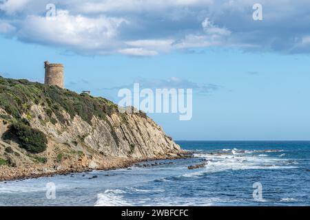An ancient stone watchtower stands atop a cliff with lush greenery ...