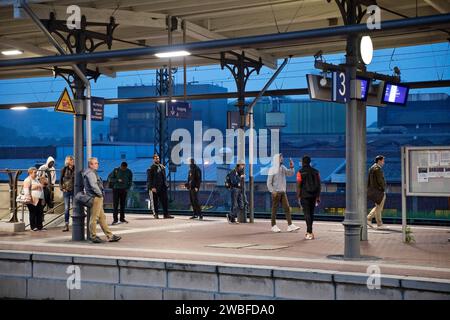 People on the platform early in the morning in front of the stainless steel plant, main railway station, Witten, North Rhine-Westphalia, Germany Stock Photo