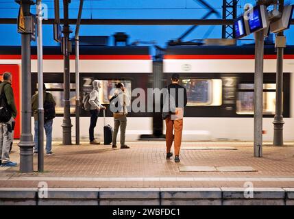 People on the platform early in the morning with passing train, Central Station, Witten, North Rhine-Westphalia, Germany Stock Photo