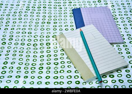 Two notebooks with a pencil on top of a green circled surface with copy space. Stock Photo