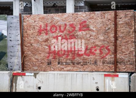 'House the Homeless' graffiti on the boarded up surrounding construction of market priced, Halifax, NS condos. Stock Photo