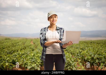 Female farmer with a laptop computer on a vineyard Stock Photo