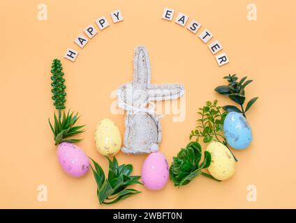 Handmade Easter decor, stylish Easter eggs, textile rabbit willow branches and flowers on light background. Easter wreath shape Stock Photo
