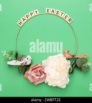 Happy Easter. Handmade Easter decor, Easter eggs and flowers on a green background. Easter wreath shape Stock Photo