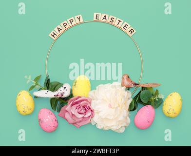 Happy Easter. Handmade Easter decor, Easter eggs and flowers on a green background. Easter wreath shape Stock Photo