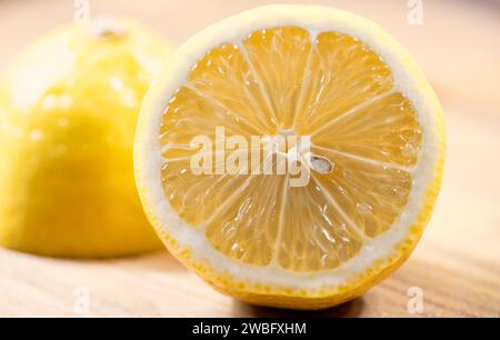 Half Cut Fresh Lemon with other half in background, bright and refreshing. Stock Photo
