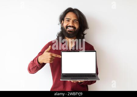 Cool young indian man showing laptop with white screen Stock Photo