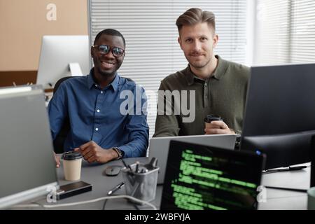 Two Diverse Programmers in Office Smiling at Camera Stock Photo