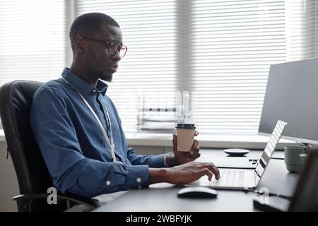 IT Professional Working and Drinking Coffee Stock Photo