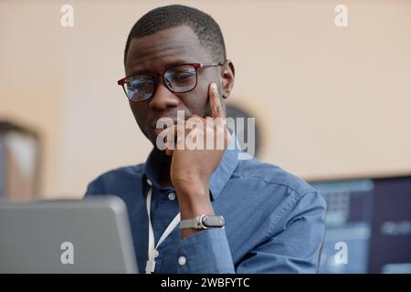 Male IT Worker Looking Down at Computer Screen Stock Photo