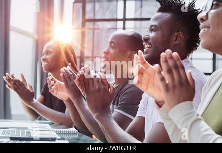 Multi ethnic business group greets somebody with clapping and smiling Stock Photo