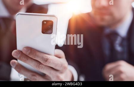 Businessman typing success on touch screen phone at AI generated workplace Stock Photo