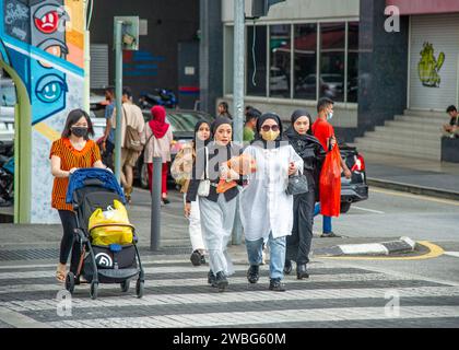 February 15 -2023-Kuala Lumpur Malaysia-Muslim women cross the boulevard on the pedestrian crossing Stock Photo