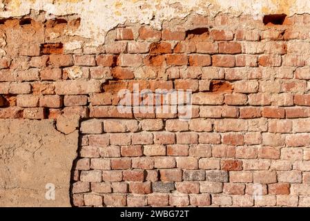 Old wall texture with plaster and peeling background with exposed brick. Ideal for background with space for copies Stock Photo