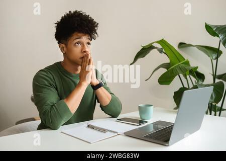 Pensive young black guy freelancer working from cozy cafe Stock Photo