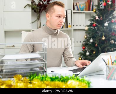Man working in Christmas decorated office Stock Photo