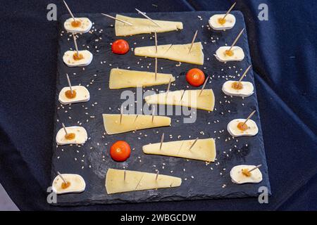 shale stone board with slices of cherry tomatoes and mozzarella cheese Stock Photo