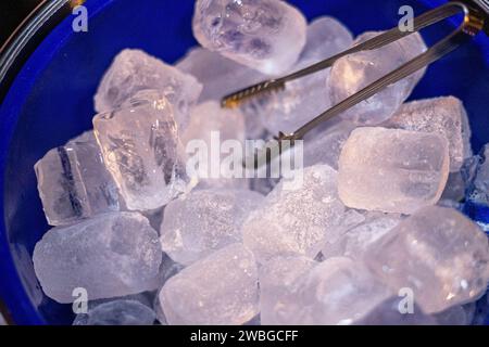 blue bucket with various ice cubes and tongs Stock Photo