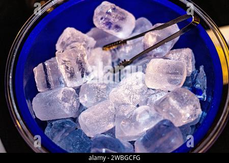 blue bucket with various ice cubes and tongs Stock Photo
